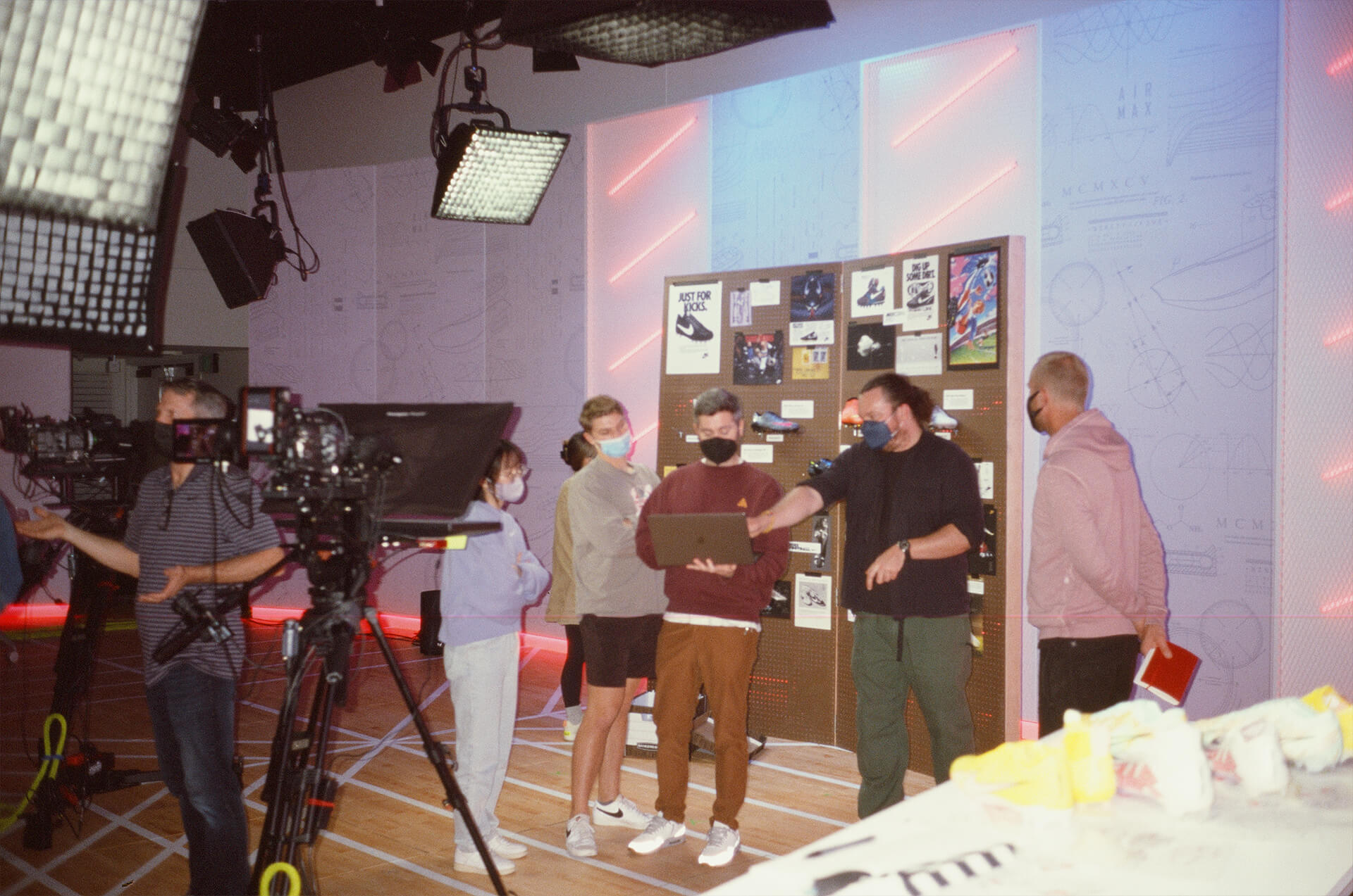 Crew reviewing a take beside the pin board on the studio floor