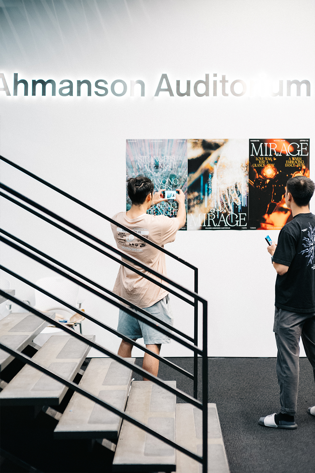 Hanging posters by the Ahmanson Auditorium stairs